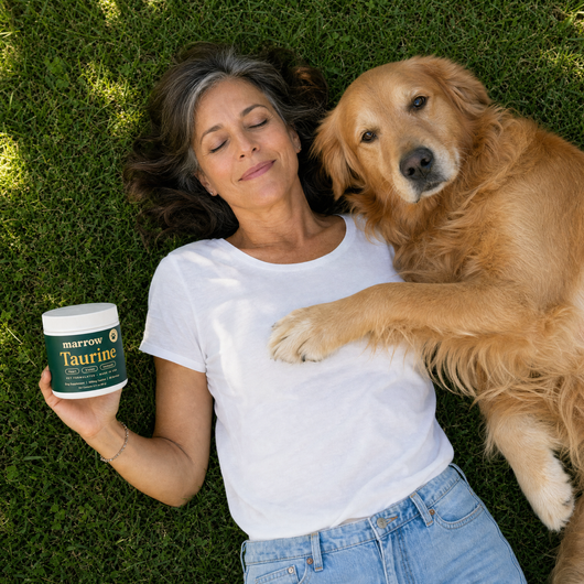 Dog mom relaxing on the grass with her senior golden retriever and Marrow Taurine
